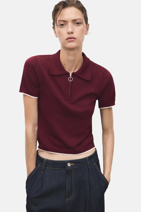 Pull ras de cou bordeaux de MANGO, avec fermeture éclair et ourlet contrasté, porté avec un jean taille haute.