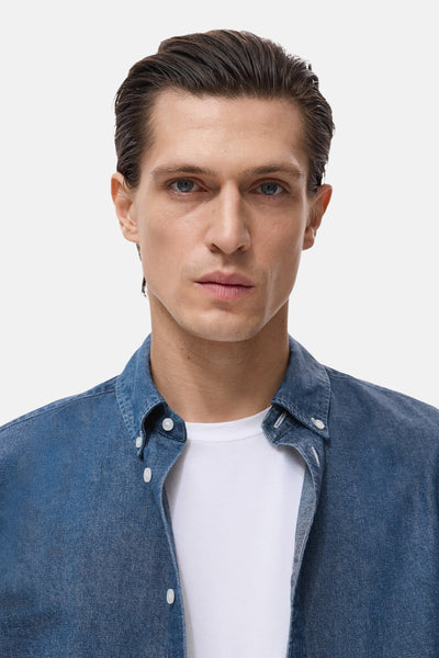 MANGO spijkeroverhemd met lange mouwen, gedragen over een effen wit T-shirt.