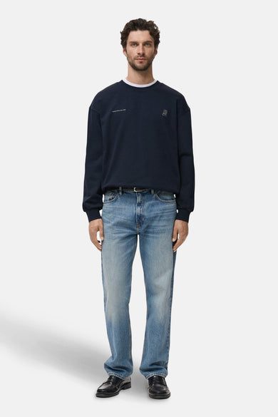 Blauwe rondehals sweatshirt van MANGO, gedragen met een spijkerbroek en zwarte loafers.