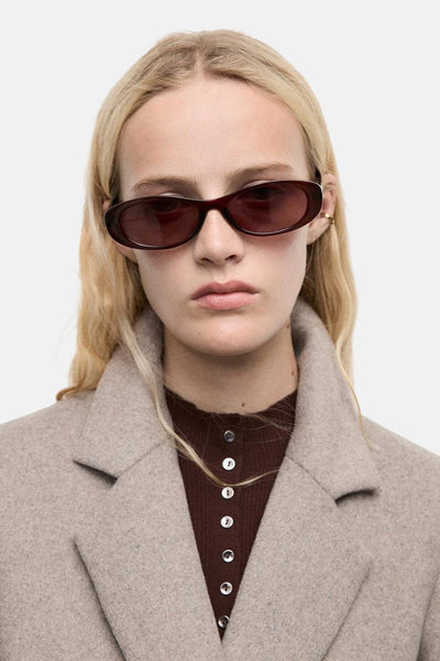 Veste longue marron de MANGO, portée sur un haut marron boutonné, avec un manteau beige.
