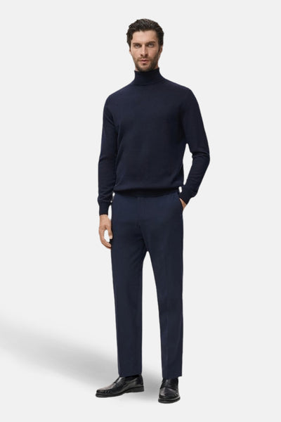 Ronde hals trui blauw van MANGO, gedragen met een broek in dezelfde kleur en zwarte loafers.