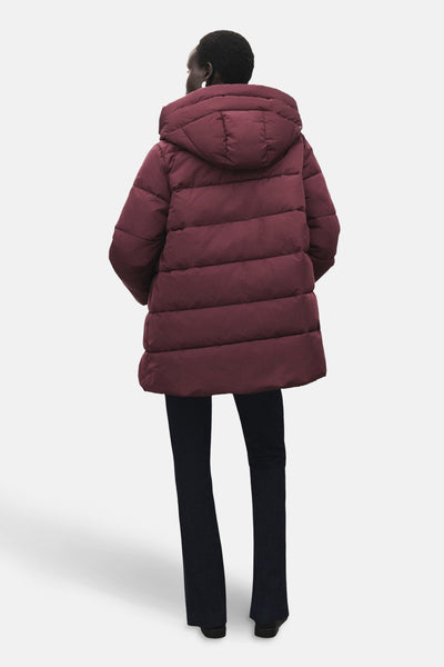 Lange bordeaux jas van MANGO, met capuchon, gedragen met een donkerblauwe broek.