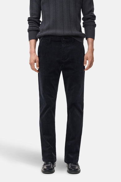 Pantalon de saison bleu en velours côtelé de MANGO, porté avec un pull en tricot gris foncé.