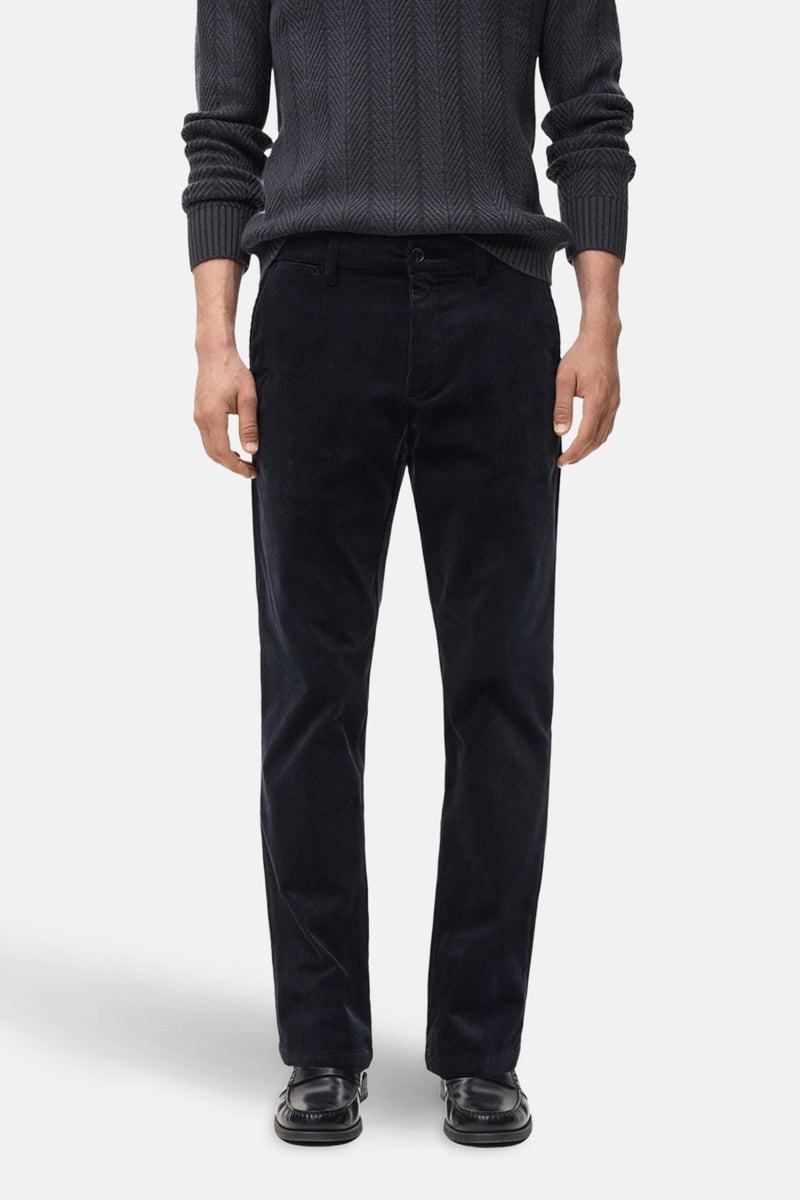 Pantalon de saison bleu en velours côtelé de MANGO, porté avec un pull en tricot gris foncé.