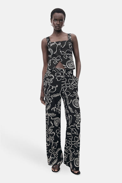Zwarte broek met bloemenpatroon van MANGO, gedragen met een bijpassend topje en zwarte sandalen met hak.