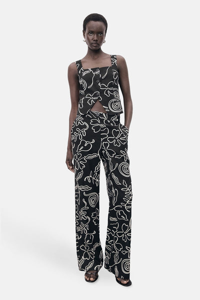 Zwarte broek met bloemenpatroon van MANGO, gedragen met een bijpassend topje en zwarte sandalen met hak.