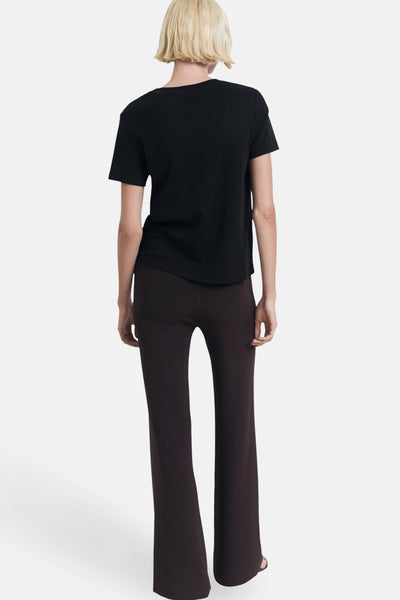Zwart T-shirt met korte mouwen van MANGO, gedragen met een bruine uitlopende broek.