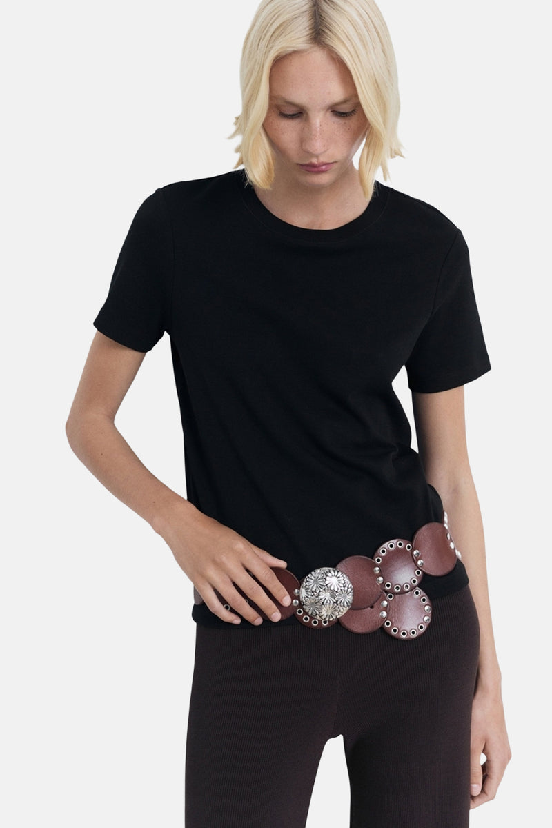 Zwart T-shirt met korte mouwen van MANGO, gedragen met een bruine riem met zilveren details en een geribbelde legging.