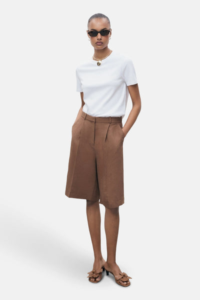 Wit T-shirt met korte mouwen van MANGO, gedragen met een gouden ketting en ovale zonnebril.