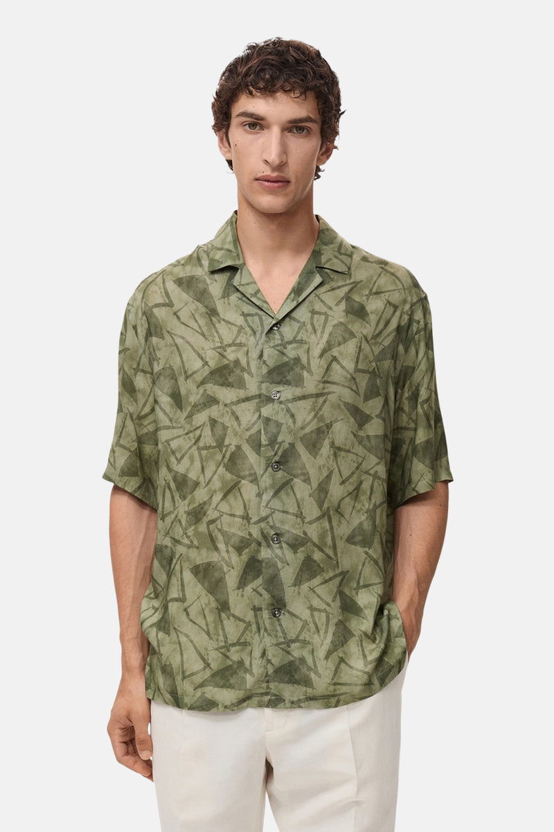 Groen overhemd met korte mouwen van MANGO, met geometrisch patroon, gedragen met een witte broek.