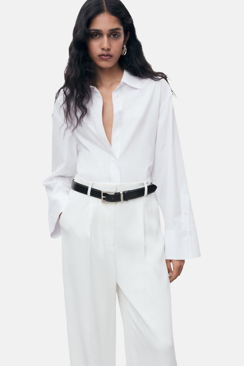 Witte blouse met lange mouwen van MANGO, gedragen met een wijde witte broek, achtergezicht.