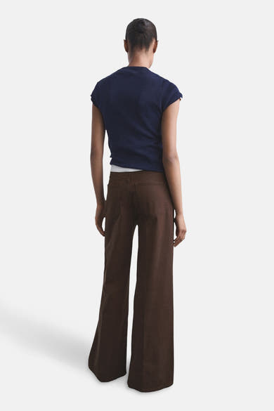 Gekleurde bruine jeans van MANGO, losse pasvorm en wijde pijpen, gedragen met een marineblauw T-shirt.
