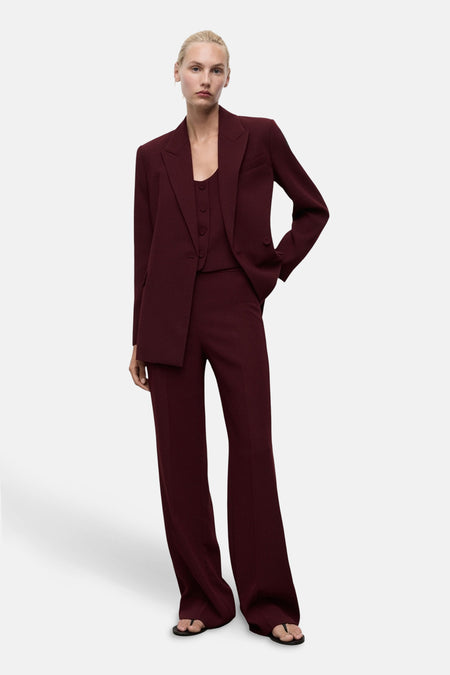 Pantalon de costume bordeaux de MANGO, avec une coupe évasée.