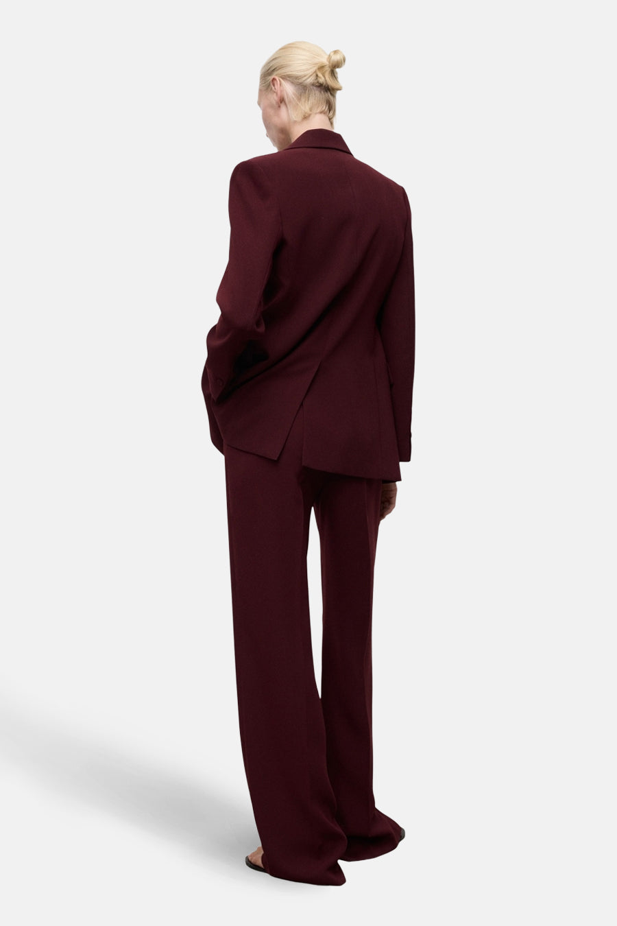 Pantalon de costume bordeaux de MANGO, coupe droite fluide, tombant sur des sandales.