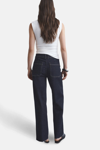 Jean large en denim bleu foncé de MANGO, vue de dos avec poches plaquées et ourlet effiloché.
