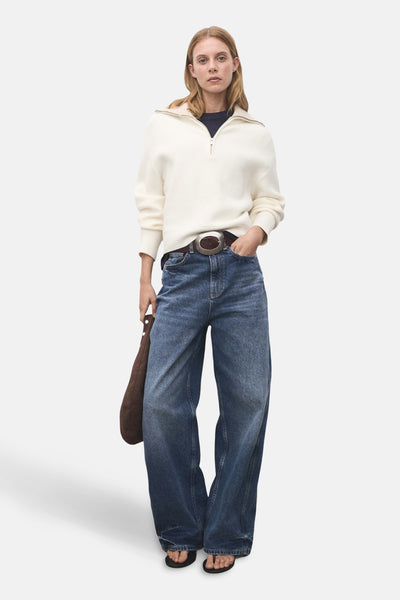 Witte coltrui van MANGO, gedragen met een wijde blauwe jeans en zwarte sandalen.