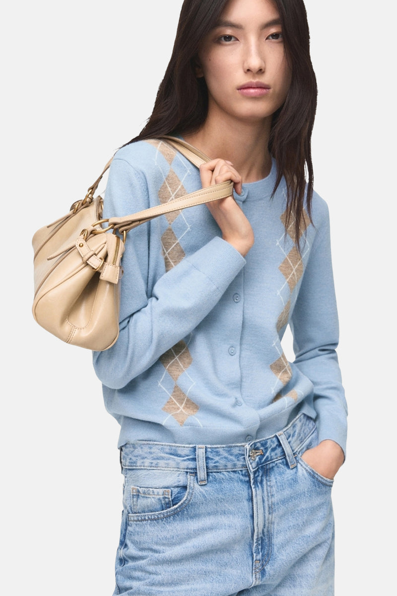 Gilet bleu à motif losanges de MANGO, porté sur un jean taille haute clair avec un sac à main beige sur l'épaule.
