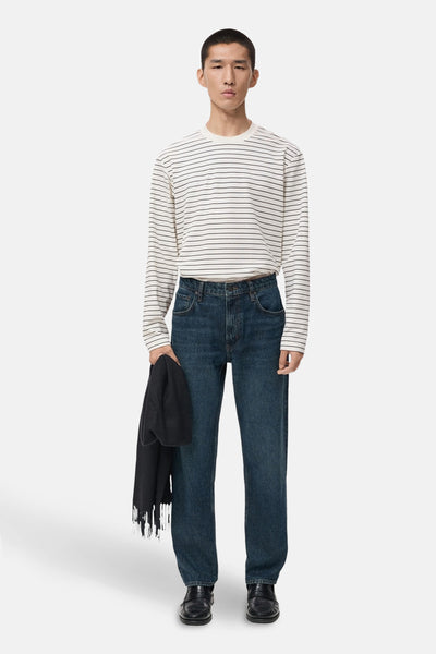 Wit gestreept T-shirt met lange mouwen van MANGO, gedragen met een blauwe jeans en zwarte schoenen.