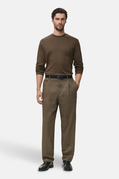 Kaki T-shirt met lange mouwen van MANGO, gedragen met een zwarte broek en riem.