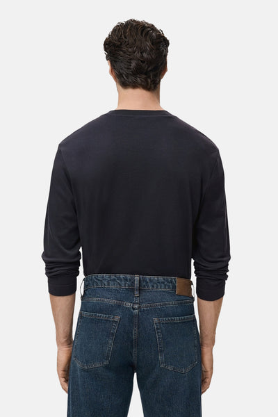 Zwart T-shirt met lange mouwen van MANGO, gedragen met een klassieke blauwe jeans en een bruine riem.