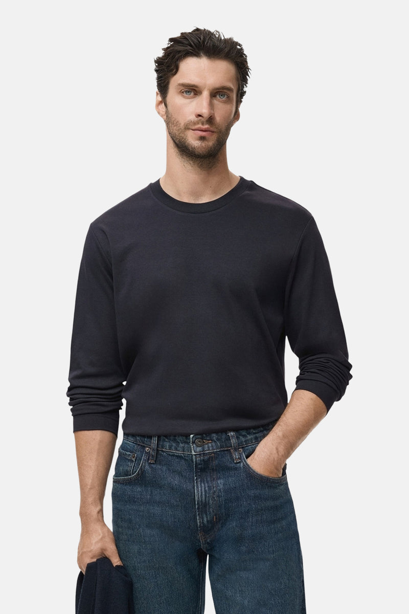 Zwart T-shirt met lange mouwen van MANGO, gedragen met een donkere spijkerbroek en een zichtbare zoom.