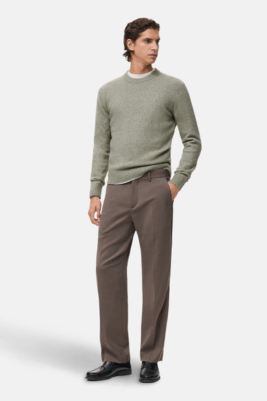 Pull col rond vert de MANGO, porté avec un pantalon marron et des mocassins noirs.