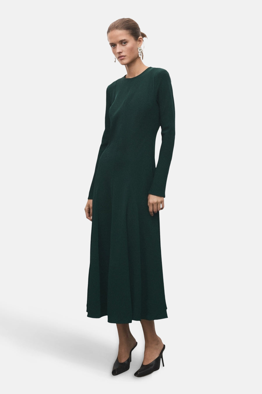 Robe longue verte à manches longues de MANGO, portée avec des escarpins noirs.
