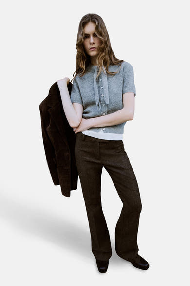 Gilet gris by MANGO, porté avec un pantalon de laine marron et une veste en daim.