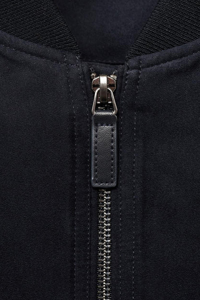Veste courte bleu marine de MANGO avec fermeture éclair et détails en cuir.
