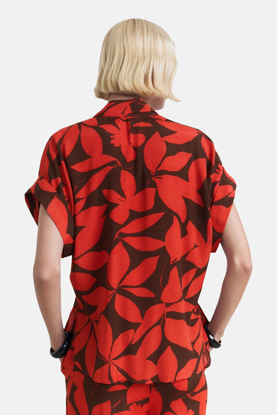 Chemise à manches courtes rouge de MANGO avec un motif de feuilles marron, vue de dos.