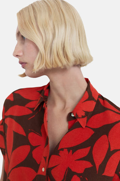 Chemise à manches courtes rouge de MANGO avec un motif floral marron et rouge.
