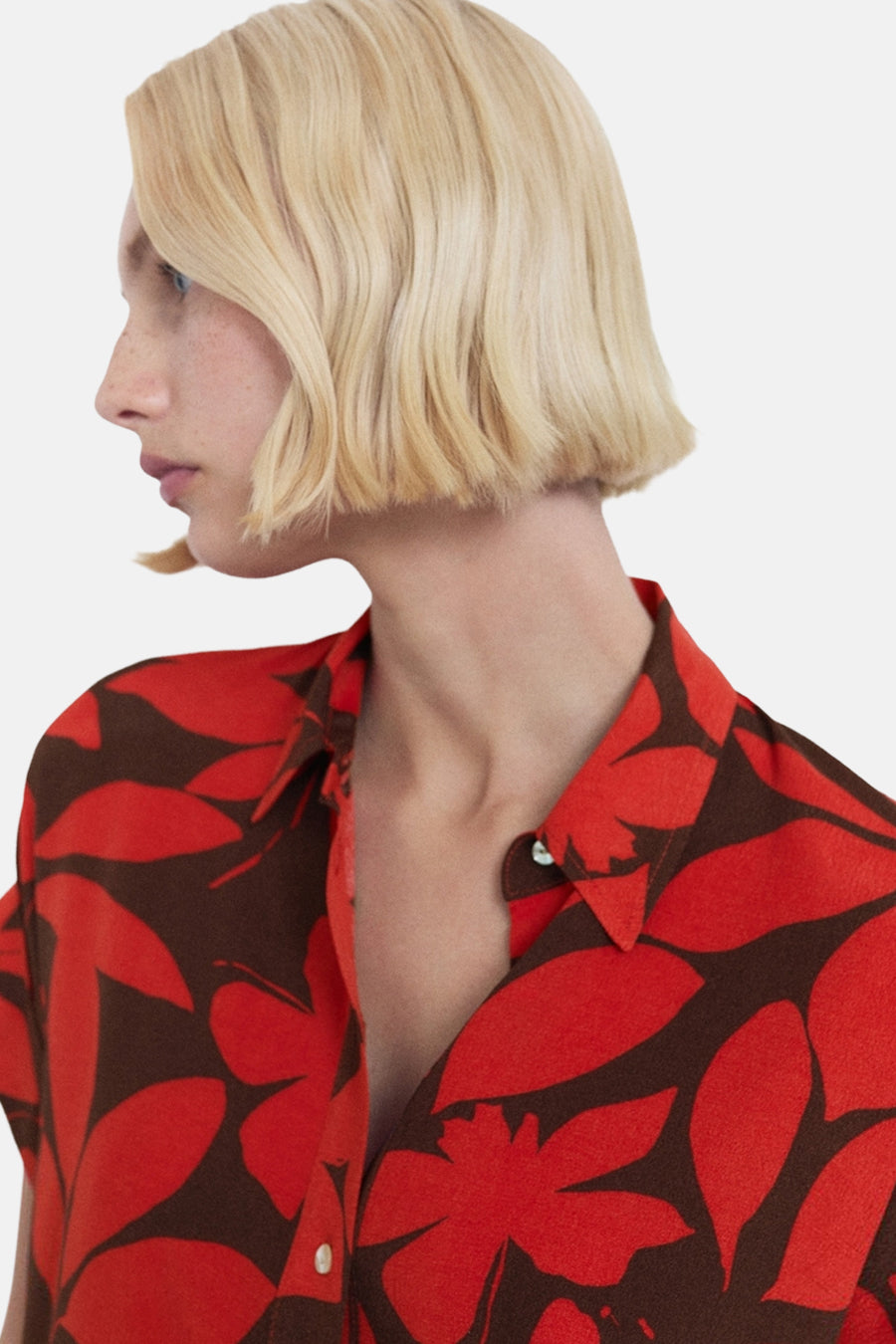 Chemise à manches courtes rouge de MANGO avec un motif floral marron et rouge.