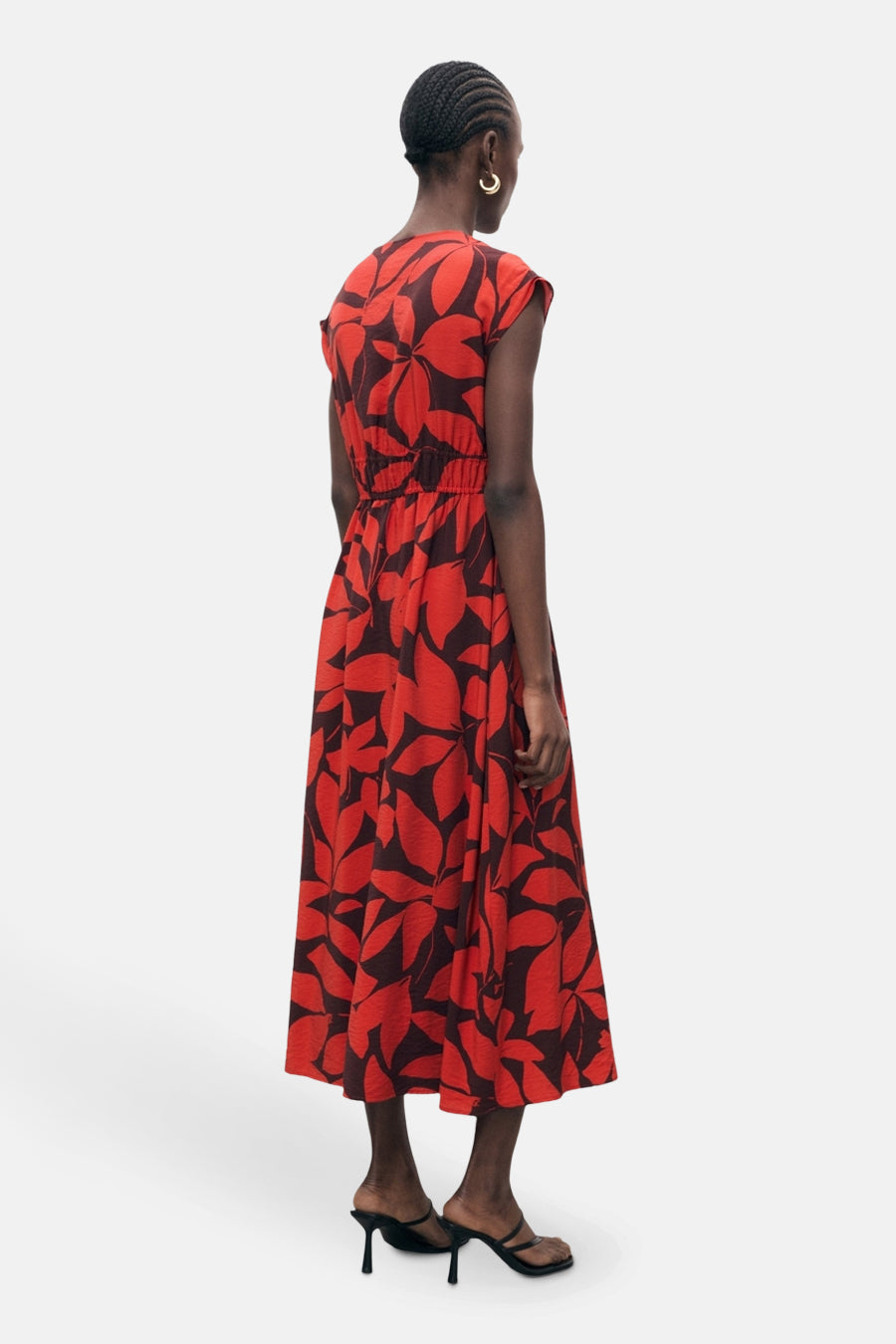 Rode jurk met bloemenprint van MANGO, midi-snit met elastische taille en zwarte hakken.