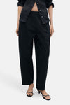 Zwarte broek van MANGO, rechte pasvorm met elastische tailleband, gedragen met een open zwart overhemd.