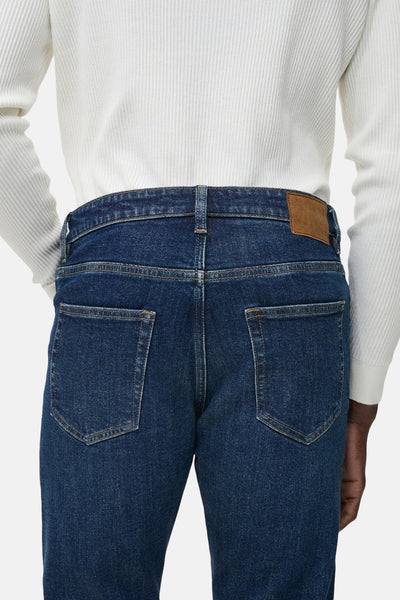 Jean fuselé bleu foncé de MANGO, vue arrière, avec ceinture et poches carrées.
