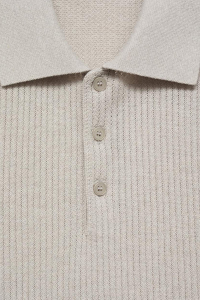 Polo écru à manches courtes de MANGO, en maille côtelée avec une patte de boutonnage à trois boutons.
