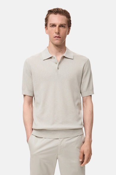 Ecru poloshirt met korte mouwen van MANGO, in ribgebreide stof gedragen met een beige broek.