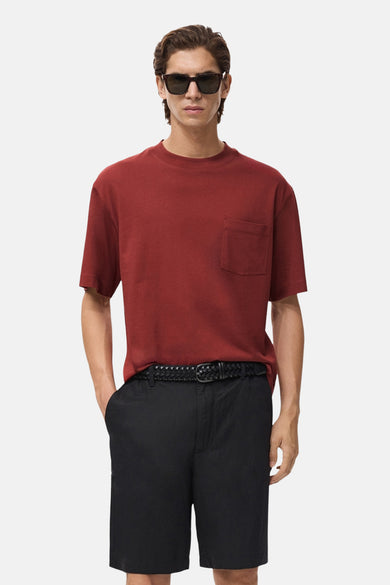 Rood T-shirt met korte mouwen van MANGO, met borstzak en gedragen met een zwarte korte broek en een gevlochten riem.