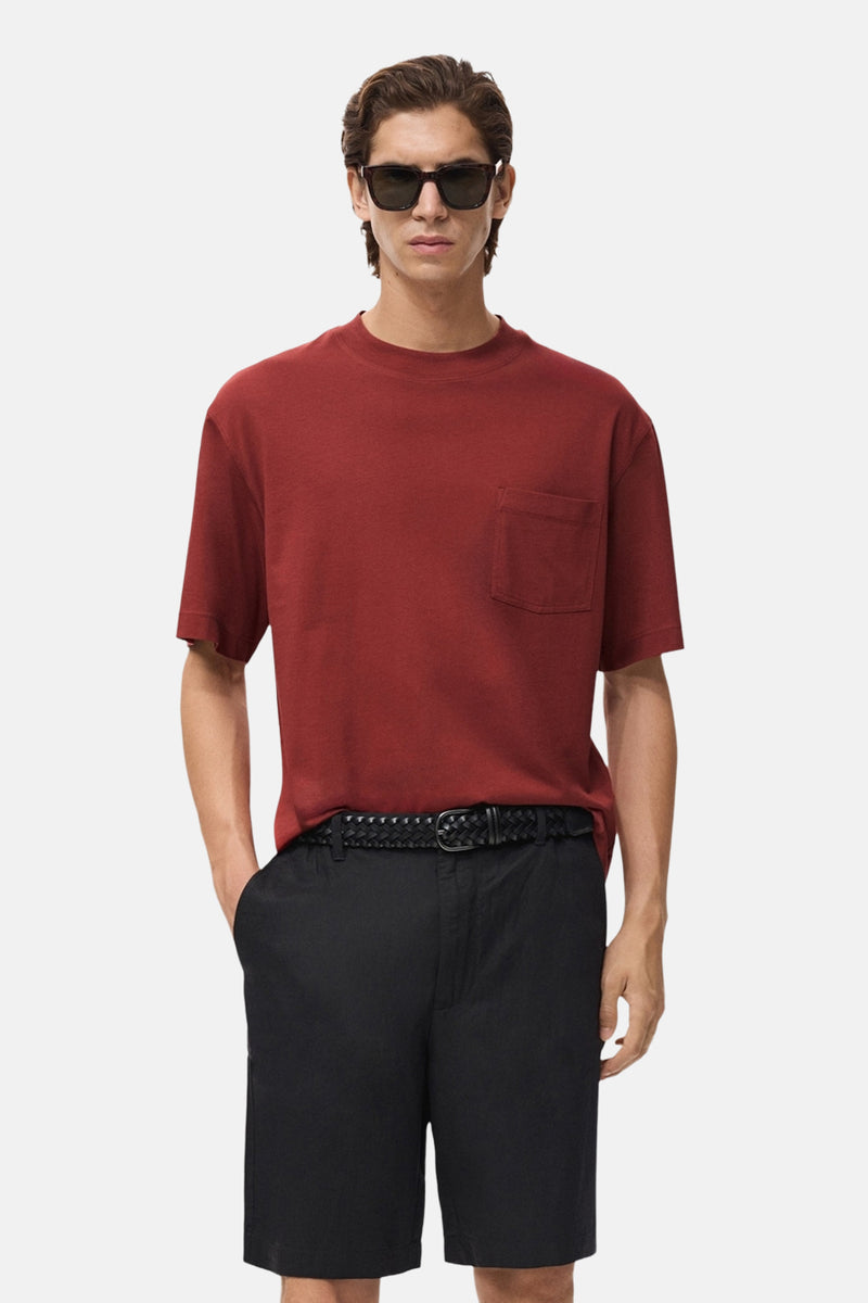 Rood T-shirt met korte mouwen van MANGO, met borstzak en gedragen met een zwarte korte broek en een gevlochten riem.