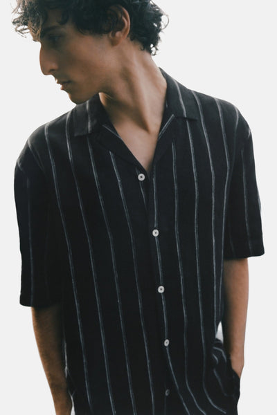 Chemise noire à rayures verticales de MANGO, à manches courtes, avec patte de boutonnage.