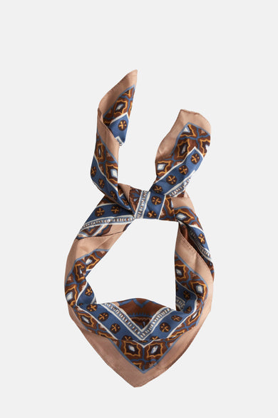 Foulard multicolore de MANGO, avec motif géométrique bleu, marron et beige, noué au milieu.
