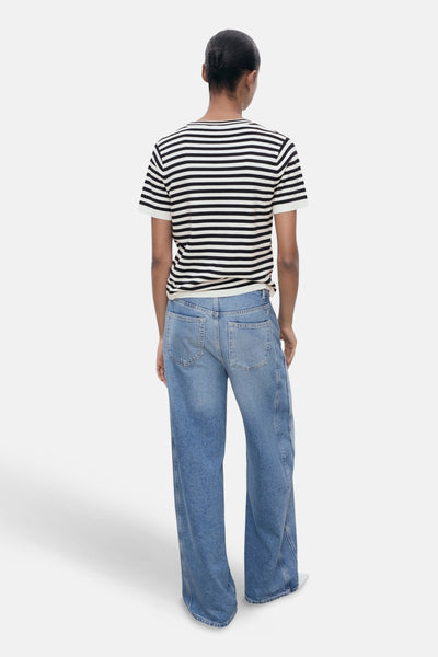 Multikleurig T-shirt met korte mouwen van MANGO, zwart-witte horizontale strepen, gedragen met een wijde blauwe spijkerbroek.