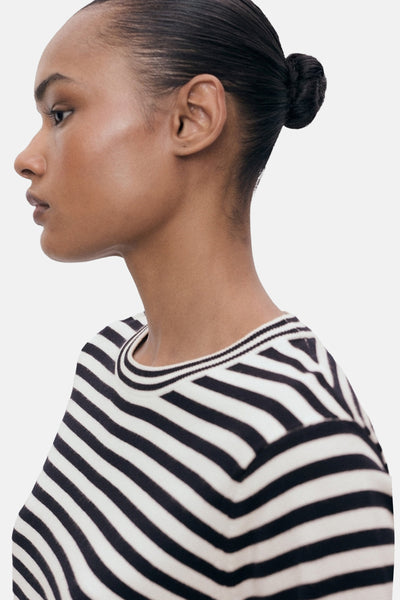T-shirt à manches courtes rayé noir et blanc de MANGO, porté par un mannequin en vue latérale.