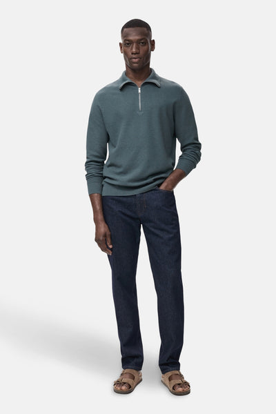 Blauwe trui met col van MANGO, gedragen met een donkere jeans en bruine leren sandalen.