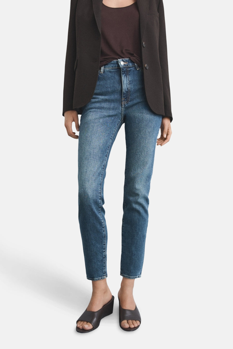 Slim jeans in medium blue denim from MANGO, worn with a blazer and wedge shoes.