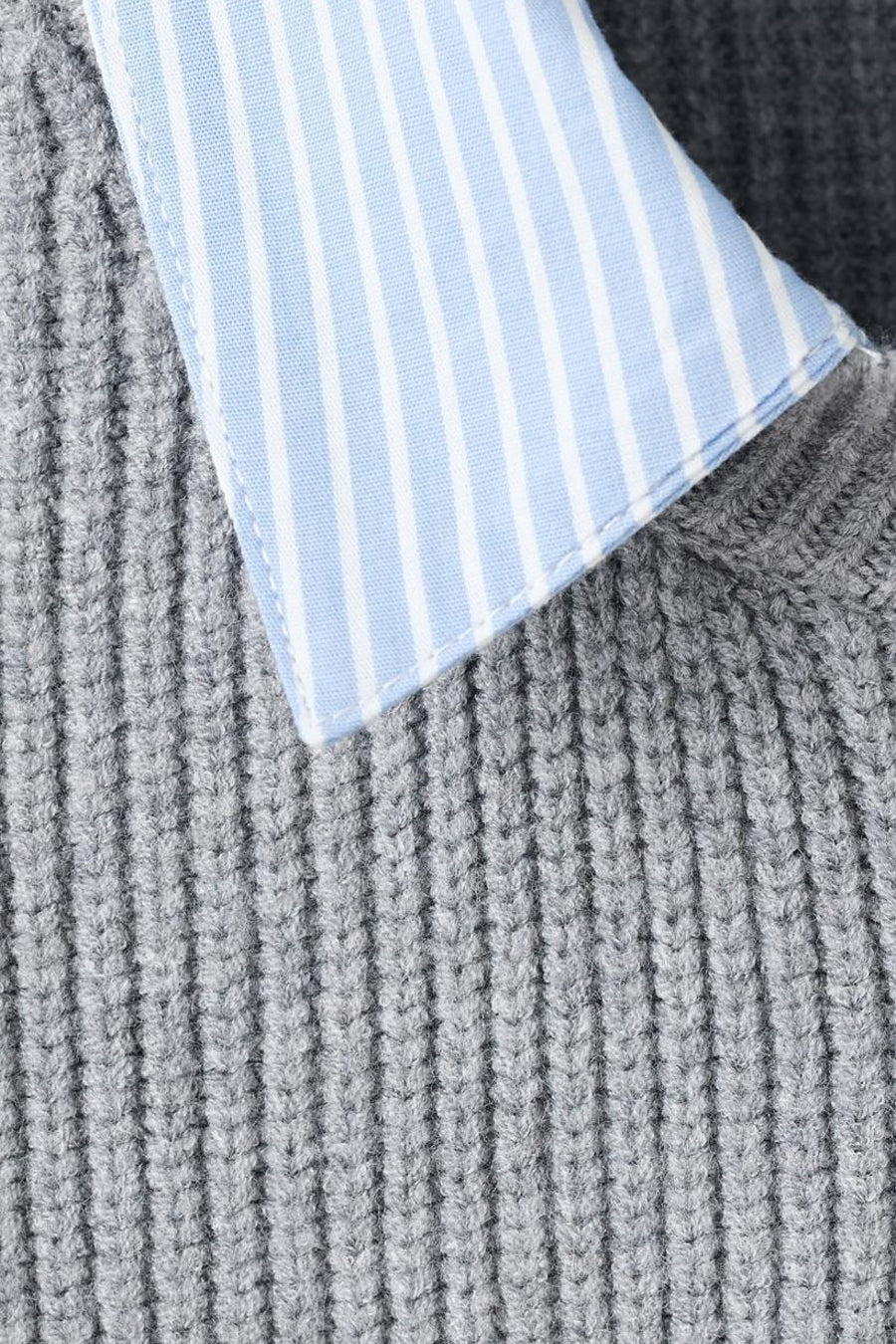 Cardigan gris de MANGO, en maille côtelée avec un col rayé bleu et blanc apparent.