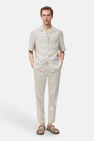 Ecru broek van MANGO, gedragen met een bijpassend overhemd en leren sandalen.