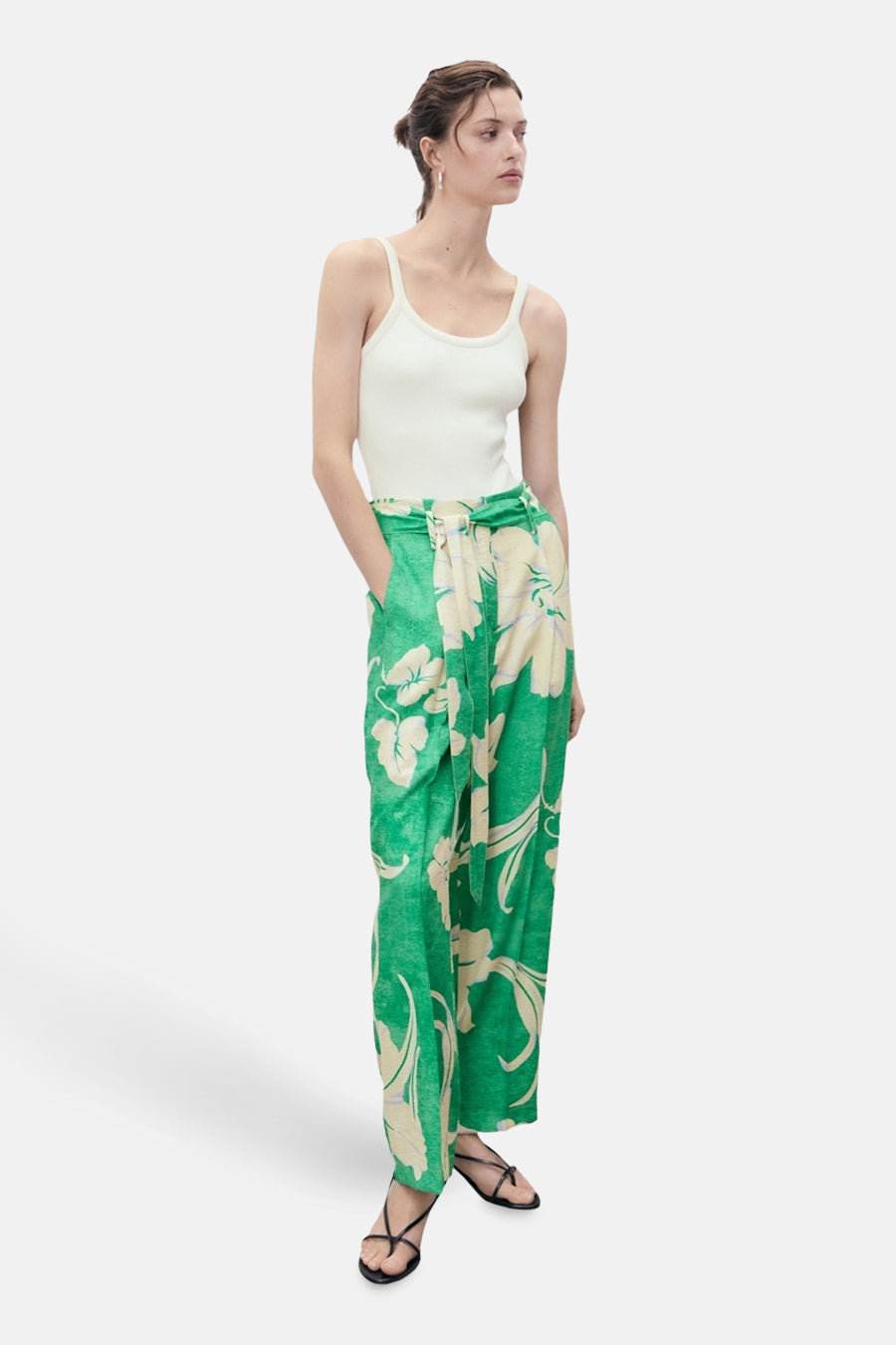 Groene broek met bloemenprint van MANGO, met bijpassende riem en zwarte sandalen.