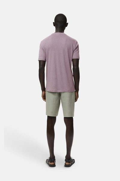 Paars T-shirt met korte mouwen van MANGO, gedragen met een groene korte broek en sandalen, achterzijde.
