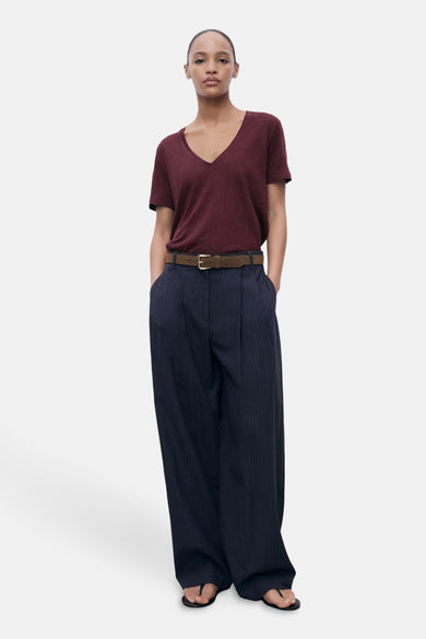 Bordeaux T-shirt met korte mouwen van MANGO, gedragen met gestreepte broek met hoge taille en bruine riem.